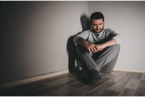 jovem deprimido sentado no chão